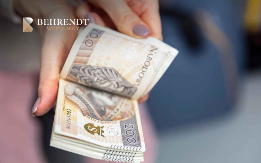 Dłonie kobiety trzymają złożony plik banknotów 200-złotowych