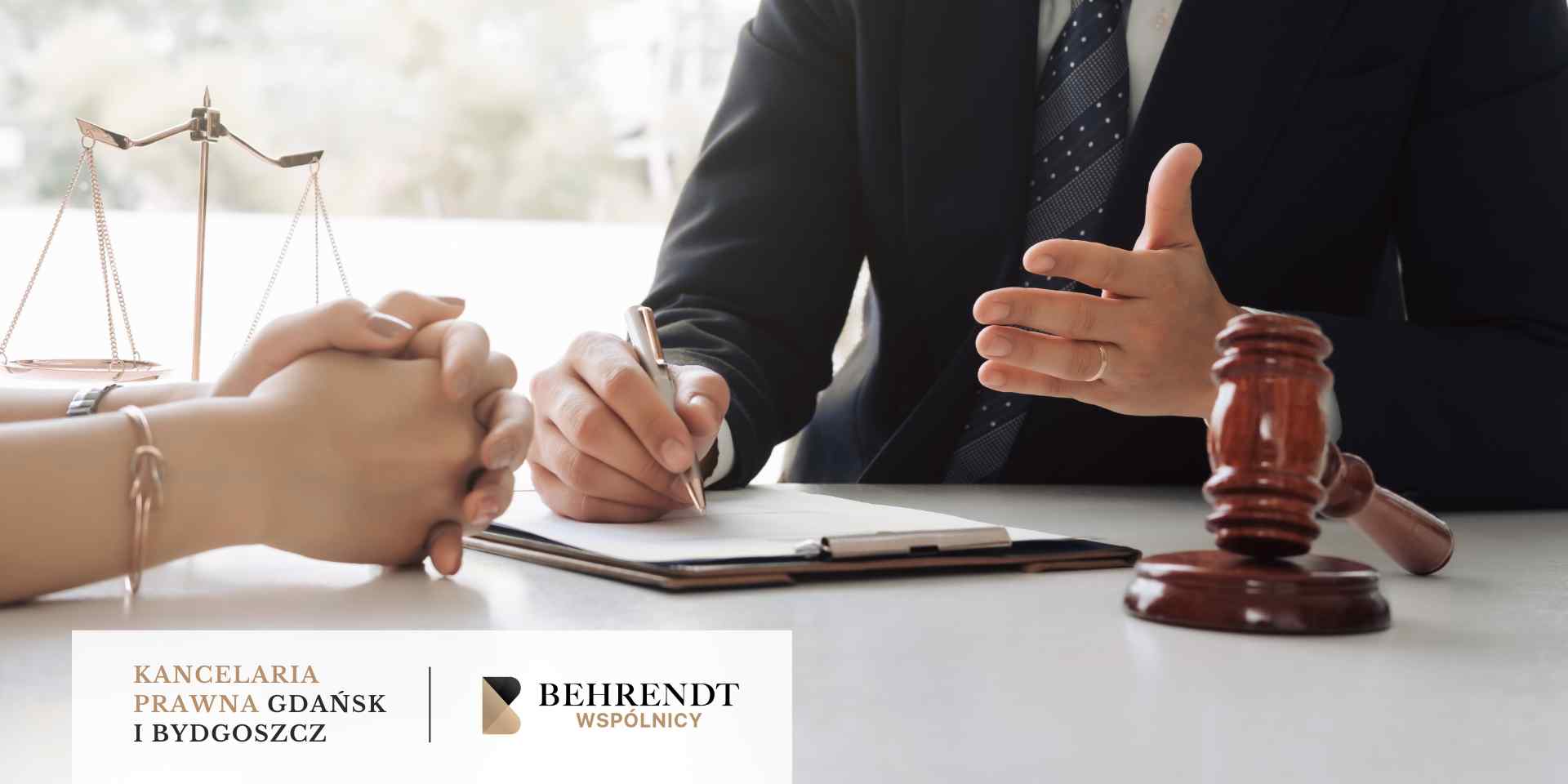 santander-pozew-frankowy <br />
Zbliżenie na biurko w trakcie spotkania prawnego, na którym widać dłonie prawnika trzymającego długopis i klienta ze złożonymi dłońmi, młotek sędziowski oraz wagę szalkową