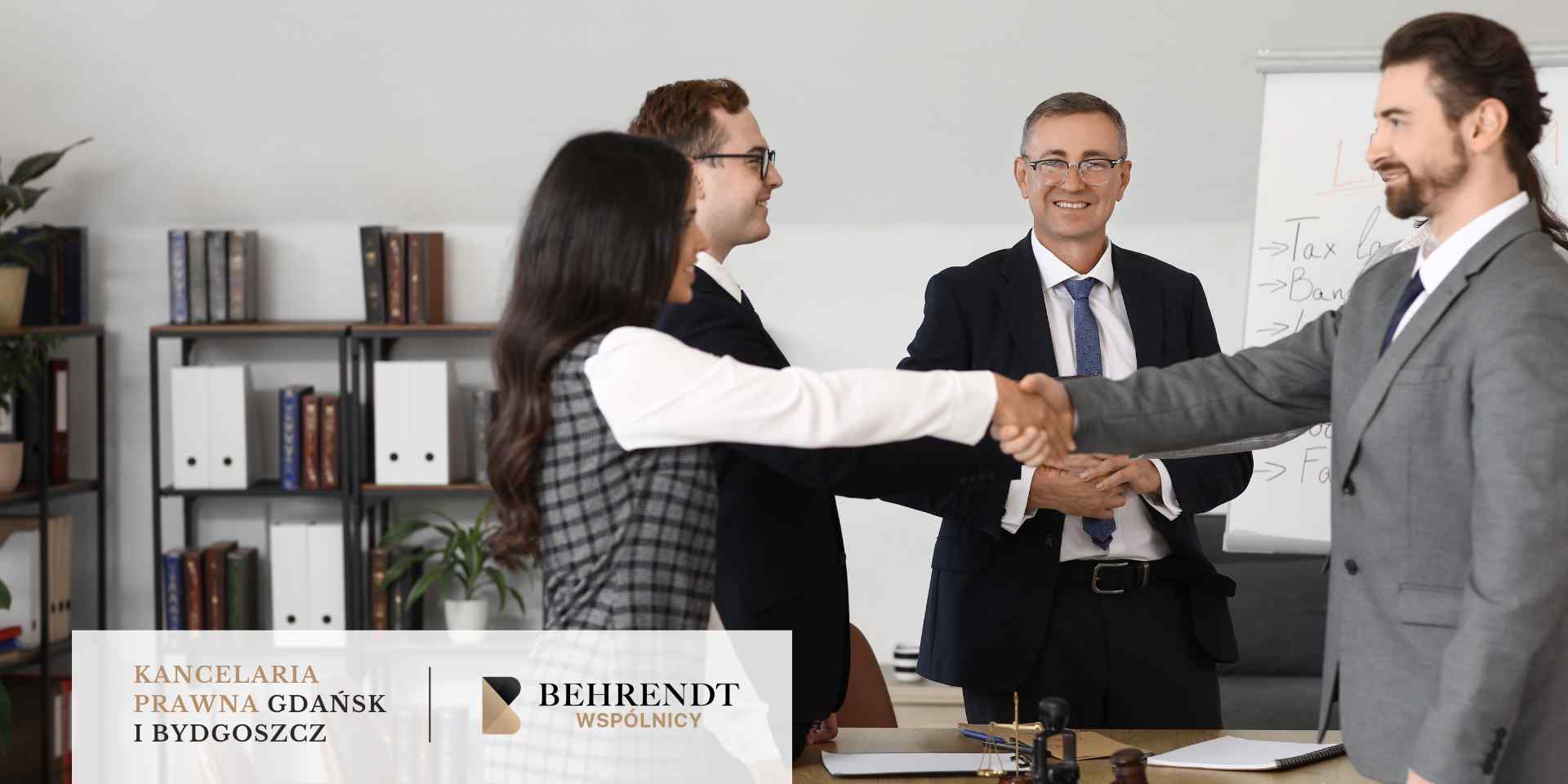 splacony-kredyt-chf-analiza-umowy 
Uśmiechnięty, starszy mężczyzna w garniturze i okularach ściska dłoń innego mężczyzny w garniturze, a w tle widać dwie inne osoby