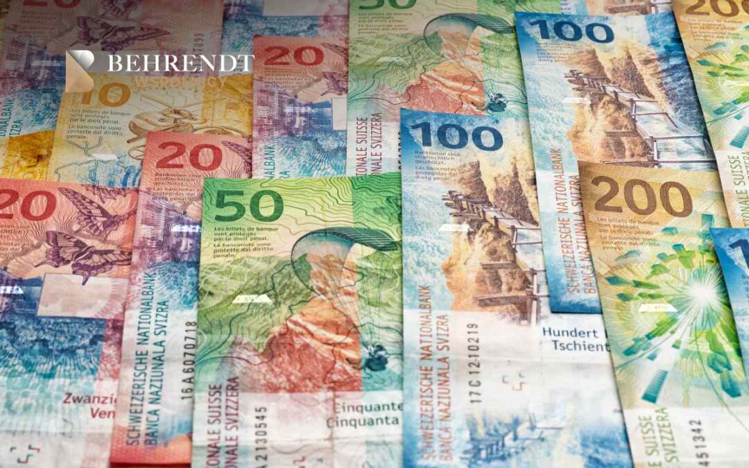 Banknoty franków szwajcarskich o różnych nominałach (20, 50, 100, 200) są rozłożone na płaskiej powierzchni