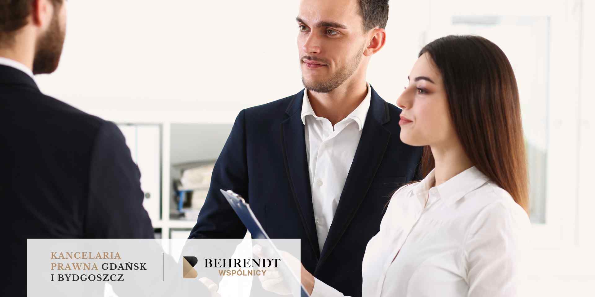 <br />
Dwoje młodych ludzi, kobieta trzymająca clipboard i mężczyzna w garniturze, rozmawiają z inną osobą, stojąc w jasnym biurze