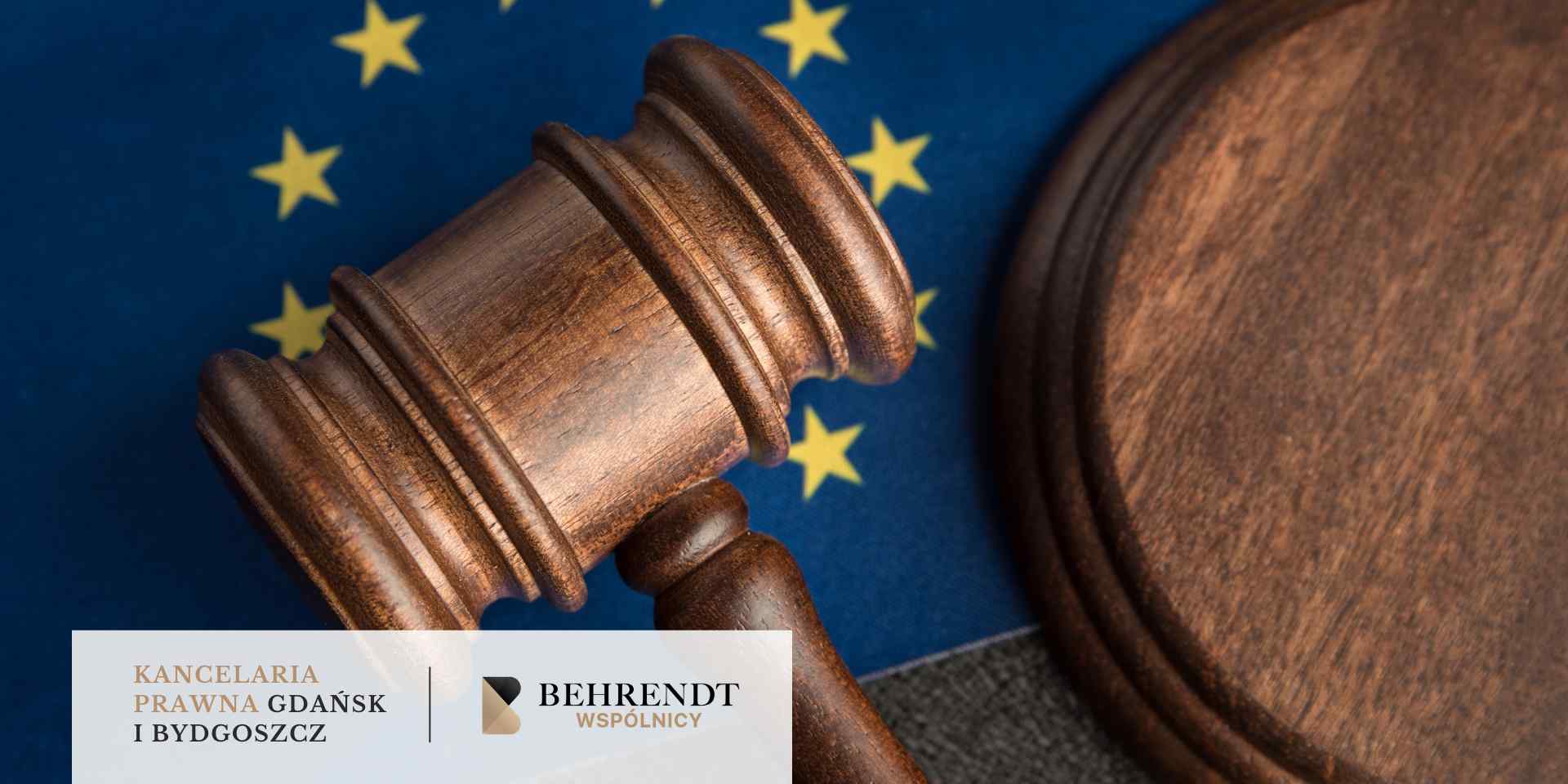 Drewniany młotek sędziowski spoczywający na tle flagi Unii Europejskiej
