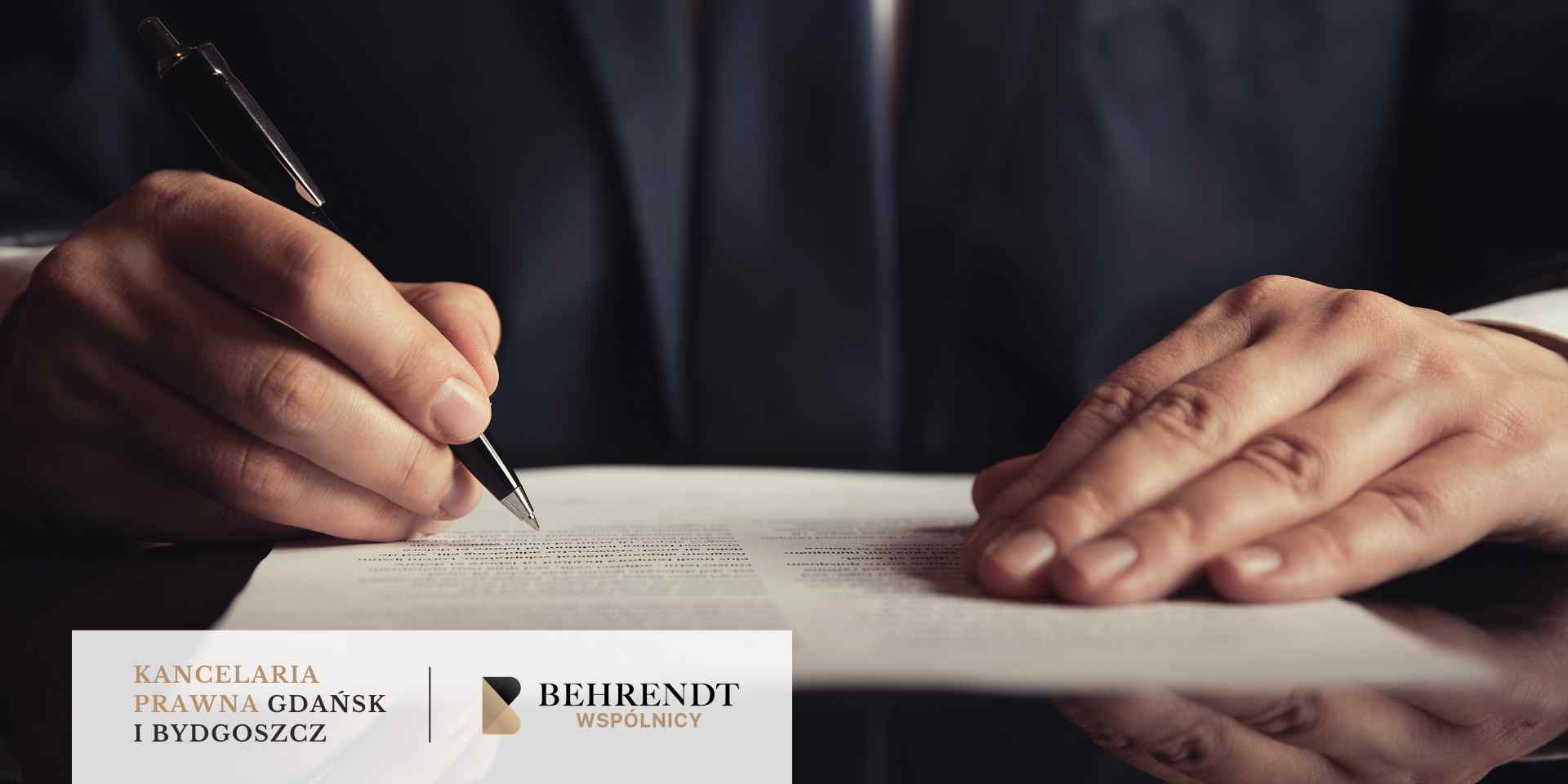 Zbliżenie na rękę mężczyzny w garniturze podpisującego długopisem dokument leżący na stole, symbolizujące podpisywanie wniosku prawnego.
