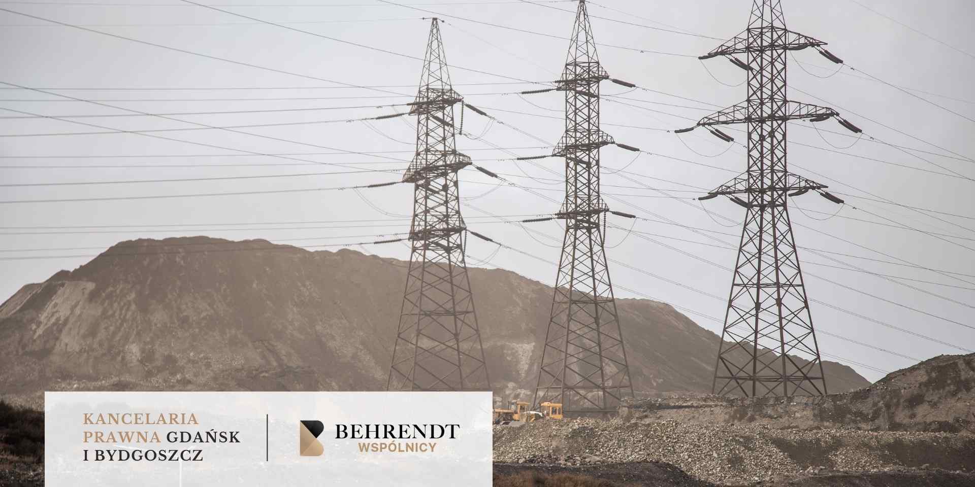 Zdjęcie przedstawia wysokonapięciowe słupy elektroenergetyczne na tle górzystego terenu