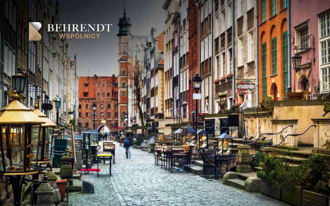 Malownicza ulica Mariacka w Gdańsku, charakteryzująca się brukowaną nawierzchnią, zabytkowymi kamienicami z przedprożami oraz licznymi stoiskami z bursztynem.