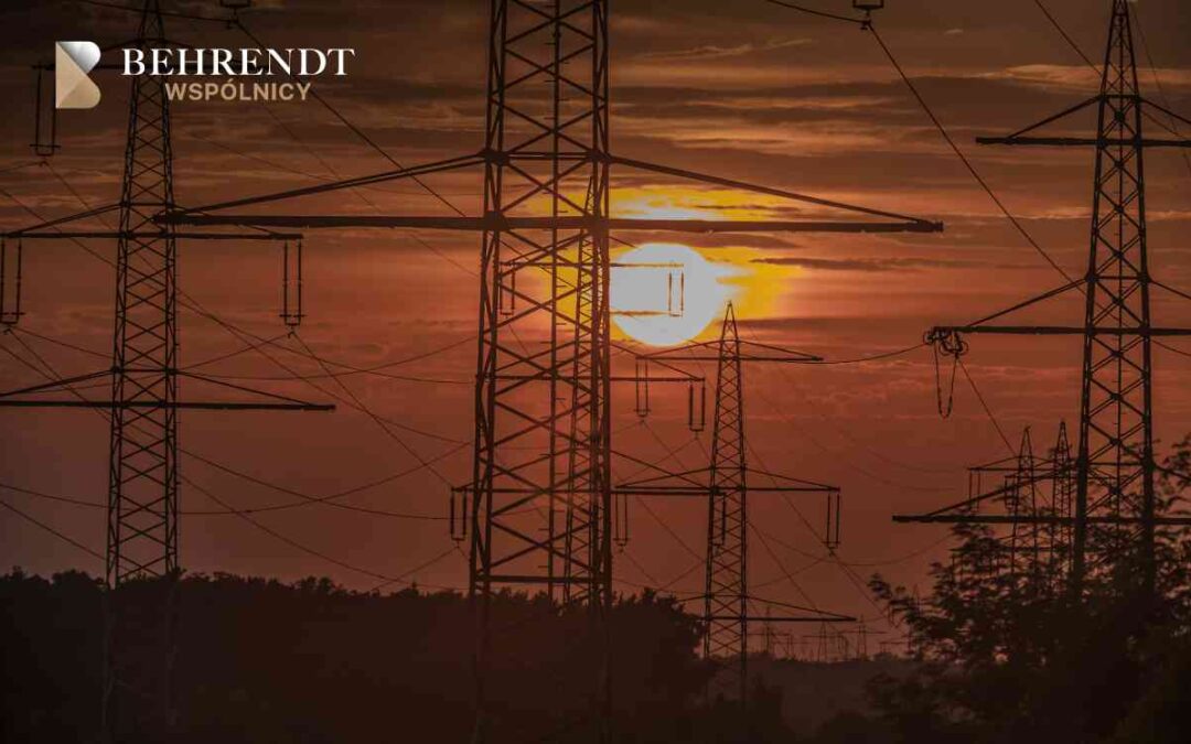 Sylwetki słupów wysokiego napięcia na tle zachodzącego słońca – ilustracja do roszczeń o odszkodowanie za linie energetyczne.
