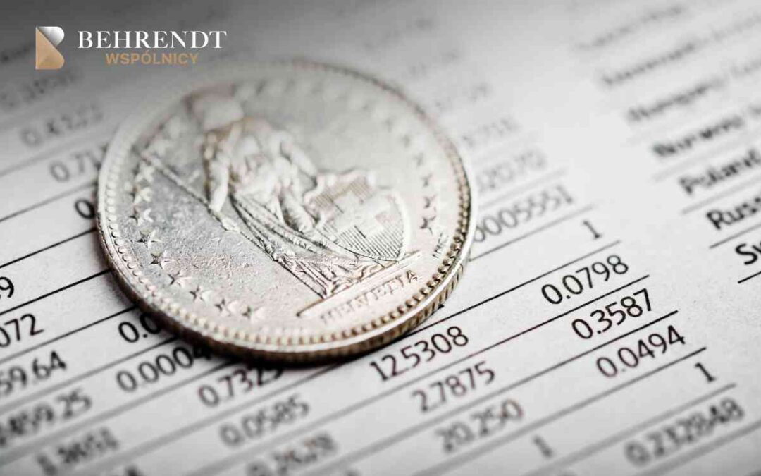 Moneta franka szwajcarskiego leżąca na tabeli kursowej z danymi finansowymi i liczbami.