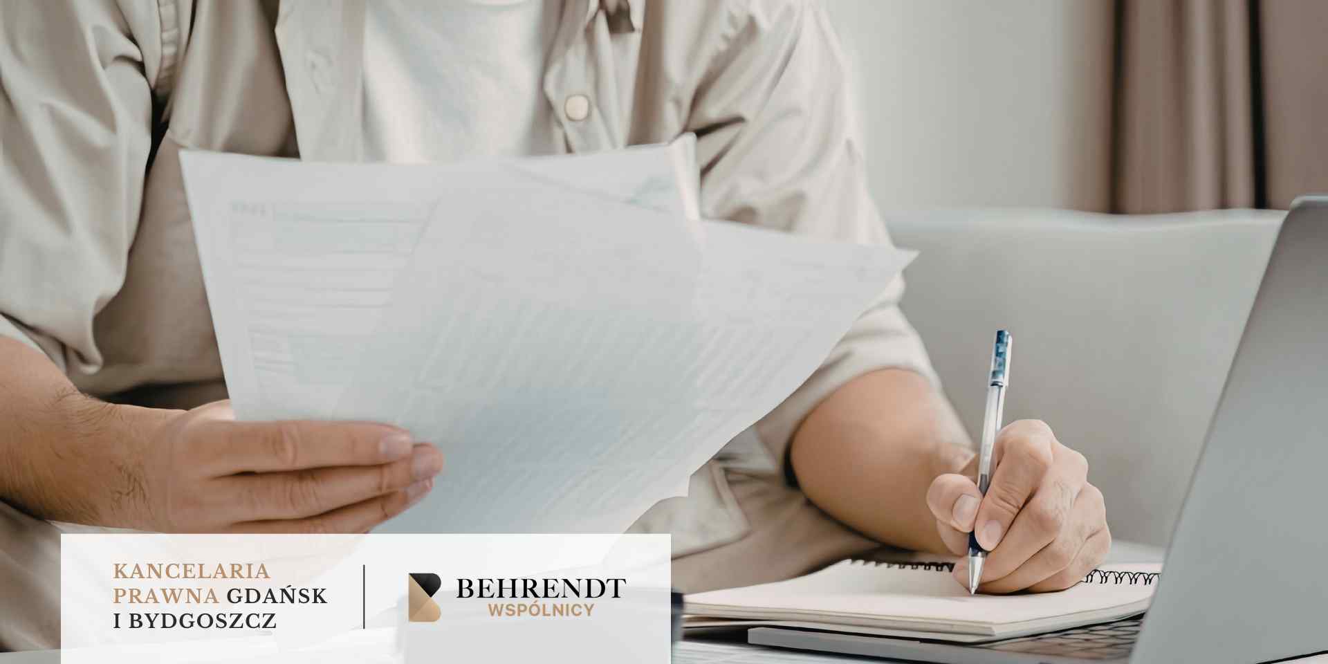 Zbliżenie na dłonie osoby siedzącej przy biurku, która trzyma kilka kartek dokumentów, prawdopodobnie umowę kredytową. Drugą ręką osoba ta wykonuje notatki w otwartym zeszycie za pomocą długopisu.