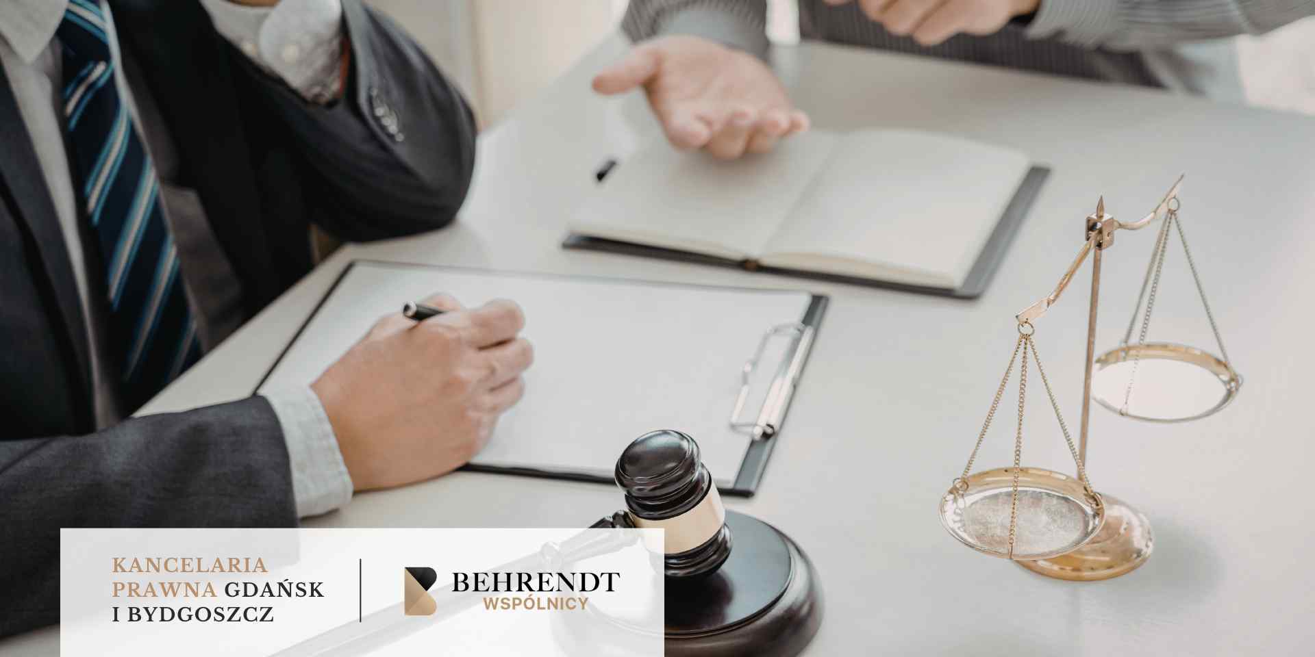 Zbliżenie na biurko w biurze prawnym, gdzie prawnik i klient, otoczeni wagą sprawiedliwości i młotkiem sędziowskim, omawiają dokumenty podczas analizy umowy kredytowej. W dolnej części grafiki znajduje się pasek z logotypem Kancelarii Behrendt Wspólnicy z Gdańska i Bydgoszczy.
