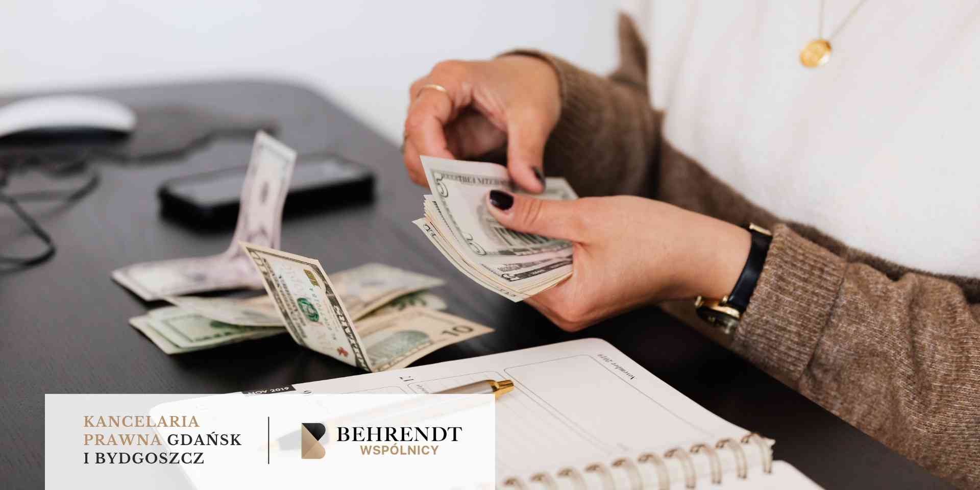 Kobieta przy biurku przelicza plik banknotów dolarowych nad otwartym kalendarzem i piórem.