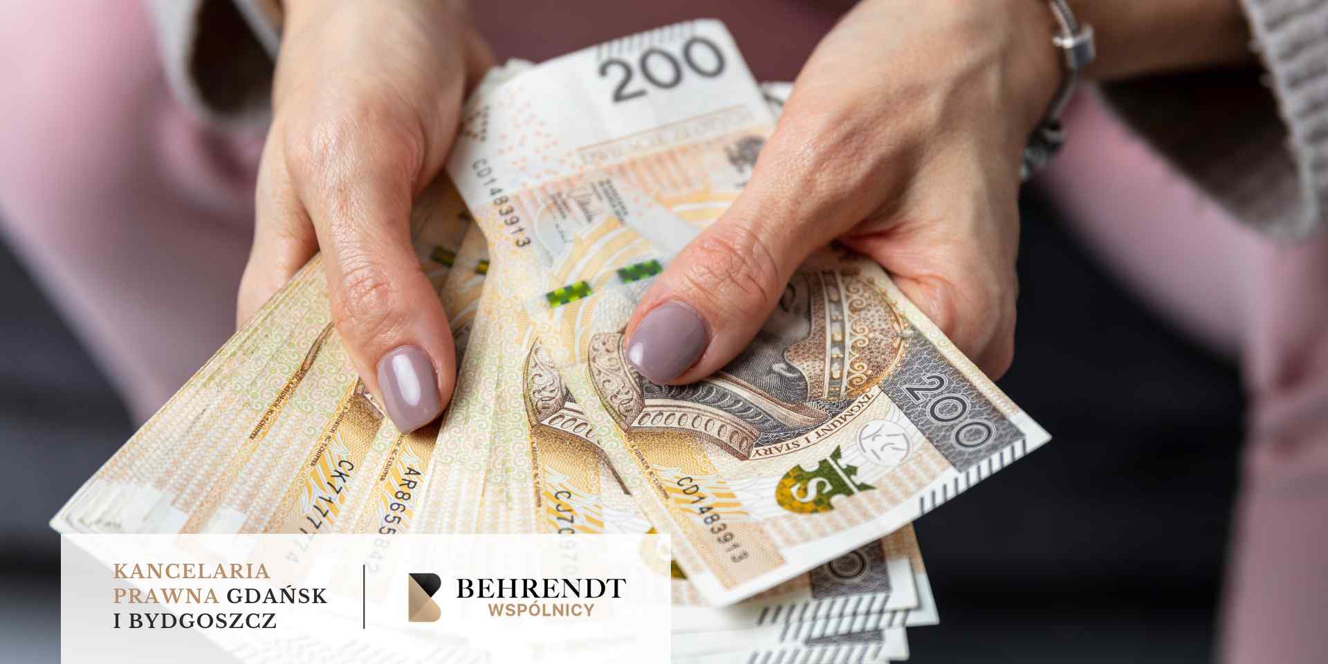 Zbliżenie na kobiece dłonie trzymające i wachlarzowato rozkładające plik banknotów o nominale 200 złotych polskich (PLN). Na pierwszym planie wyraźnie widać wizerunek króla Zygmunta I Starego oraz zabezpieczenia numizmatyczne. W dolnej części obrazu znajduje się biały pasek z logotypem Kancelarii Behrendt Wspólnicy z Gdańska i Bydgoszczy.