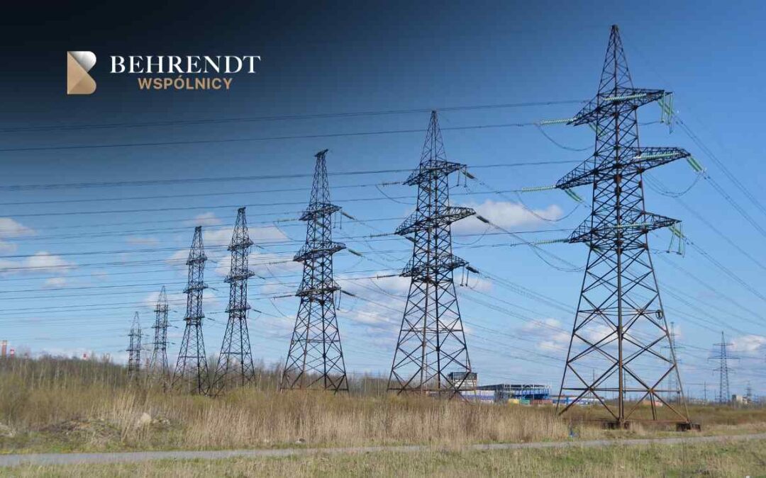 Row of steel electricity transmission towers under a blue sky, with Behrendt Wspólnicy logo in the top-left corner.