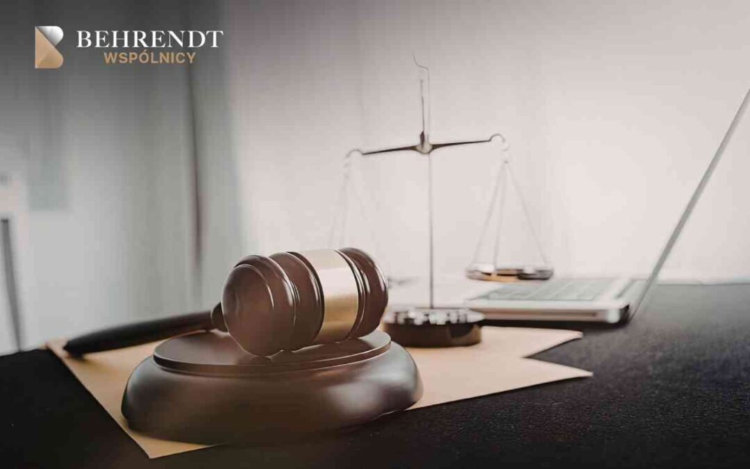 Gavel on a desk with scales of justice in the background, plus a laptop and papers, and a law firm logo in the top-left corner.