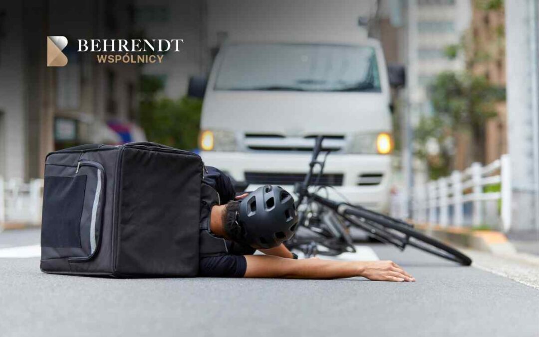 Delivery cyclist lying on the road next to a fallen bike and a large black courier backpack; a white van approaches in the background with logo in the top-left corner.