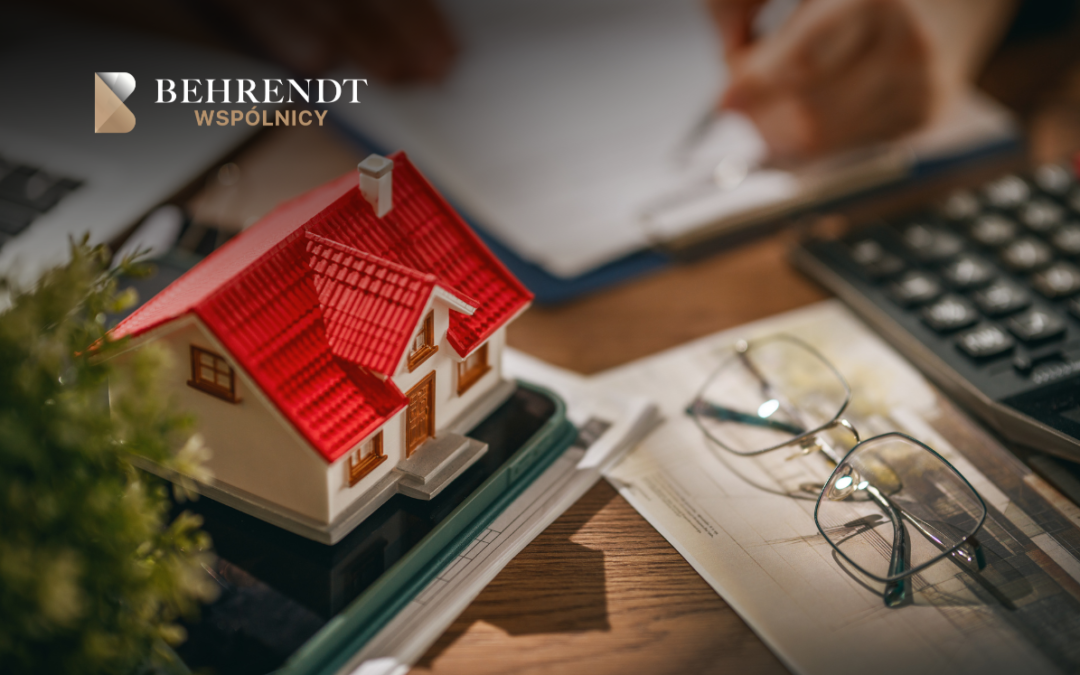 Behrendt Wspólnicy logo in the top-left; a red-roofed miniature house sits on a desk beside glasses and office papers.