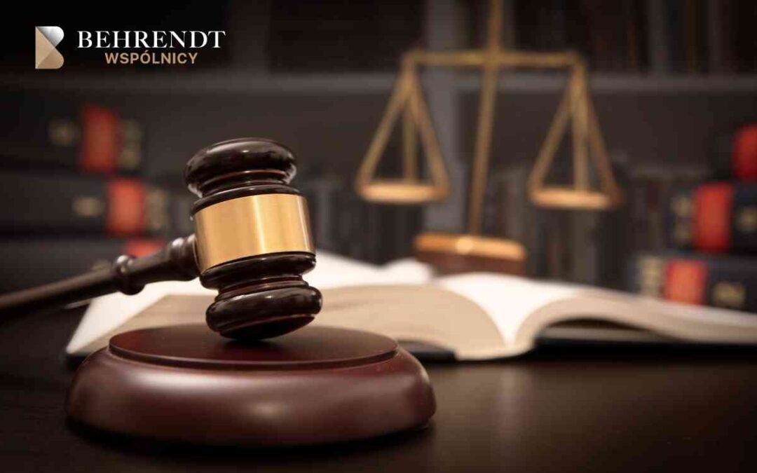 Close-up of a gavel resting on a wooden block with an open law book and blurred scales of justice in the background, signaling legal work.
