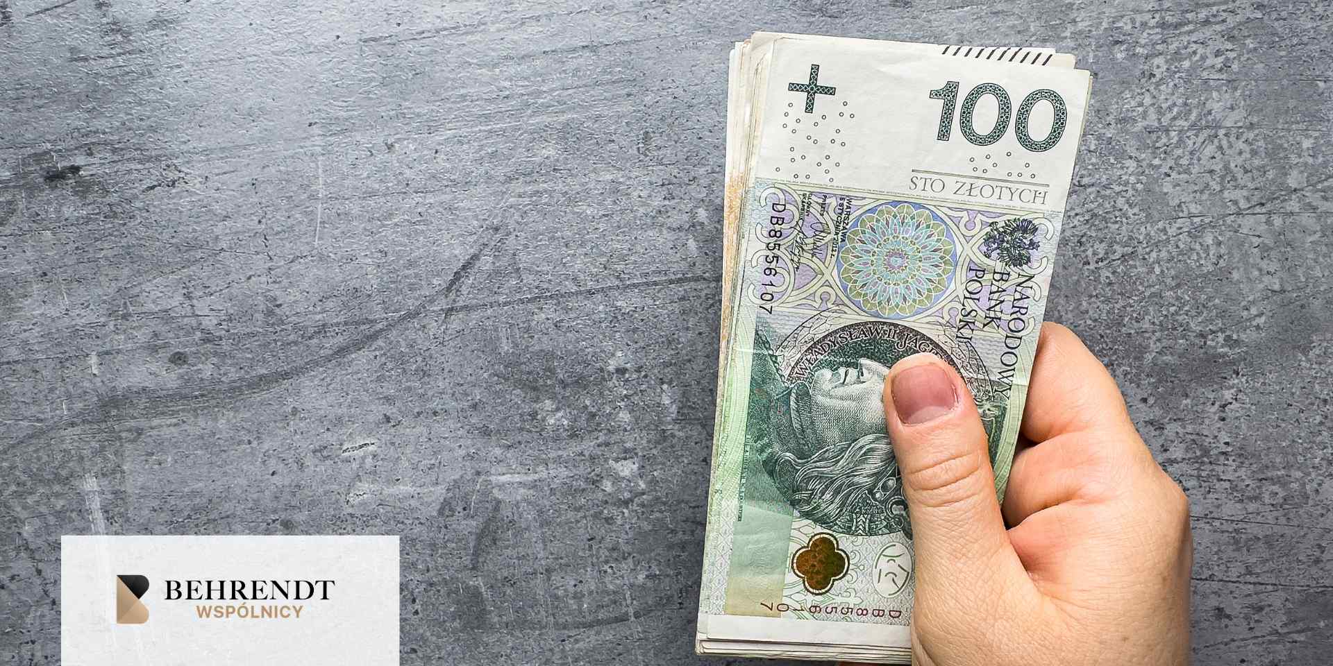 Dwie osoby podają sobie ręce. W tle widać biurko i dokumenty. 