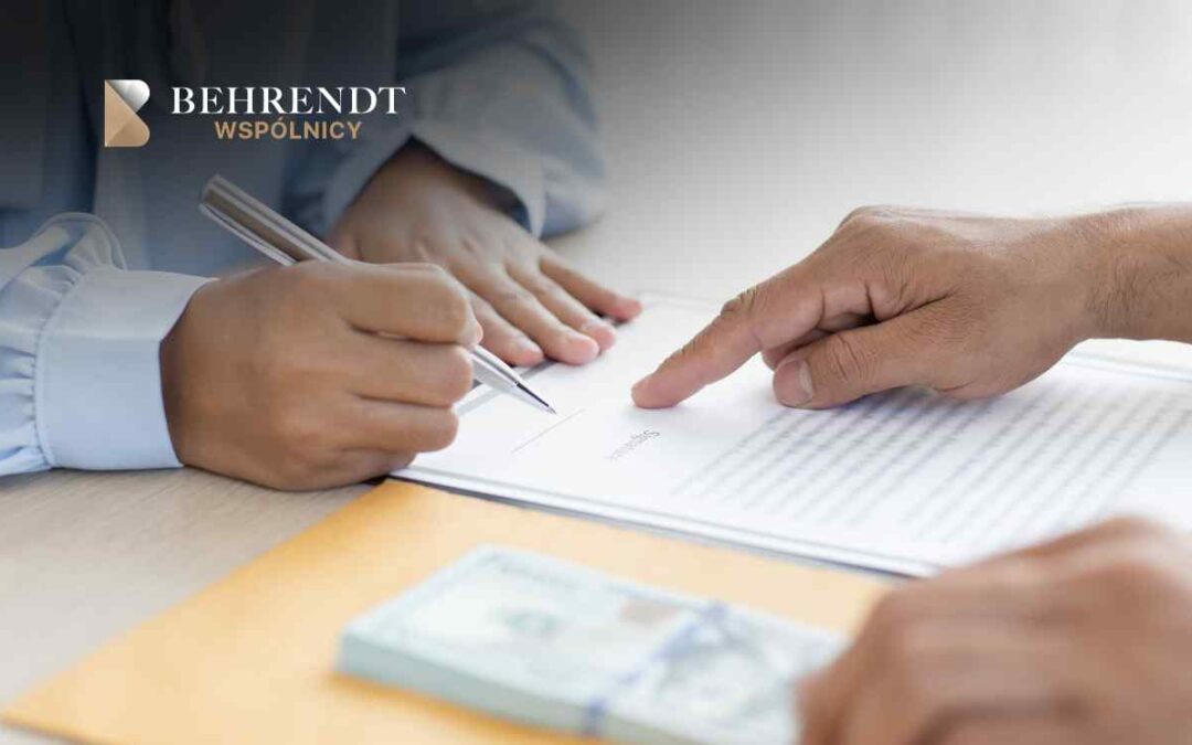 Close-up of a person signing a contract while another hand points to the text; Behrendt Wspólnicy logo in the corner.
