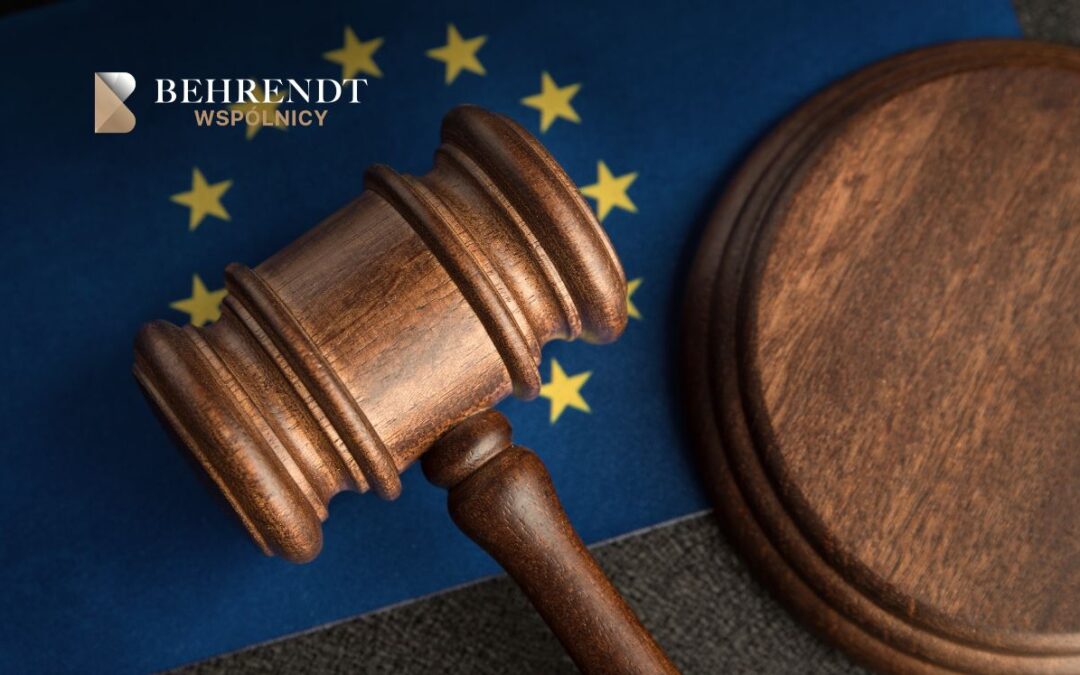 Judge's gavel resting on a desk with an EU flag in the background; Behrendt Wspólnicy logo in the corner.
