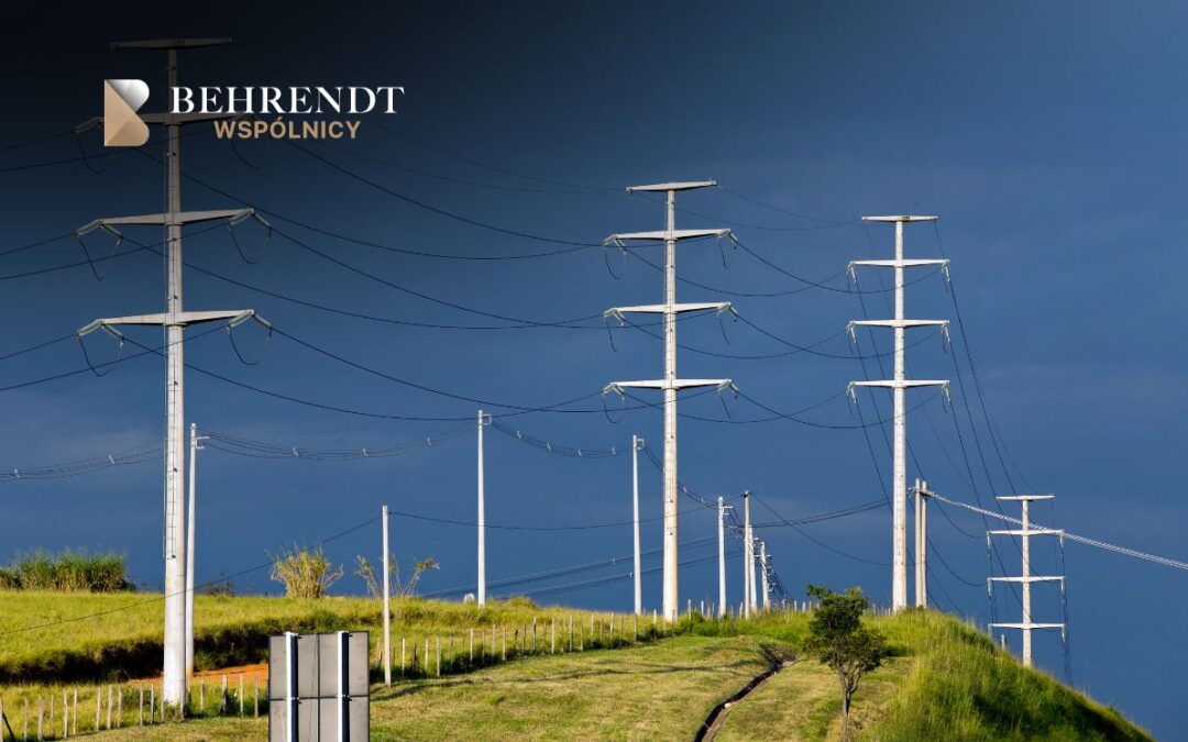 Series of white transmission towers along a grassy hillside under a dark blue sky; Behrendt Wspólnicy logo in the top-left.