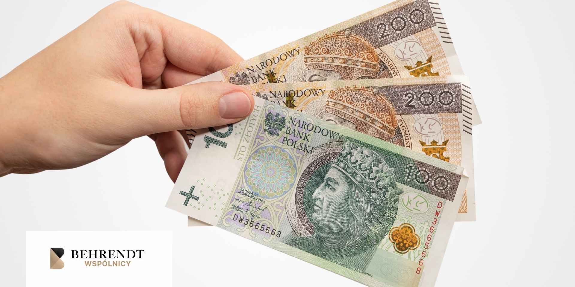dłoń trzymająca złotówki 